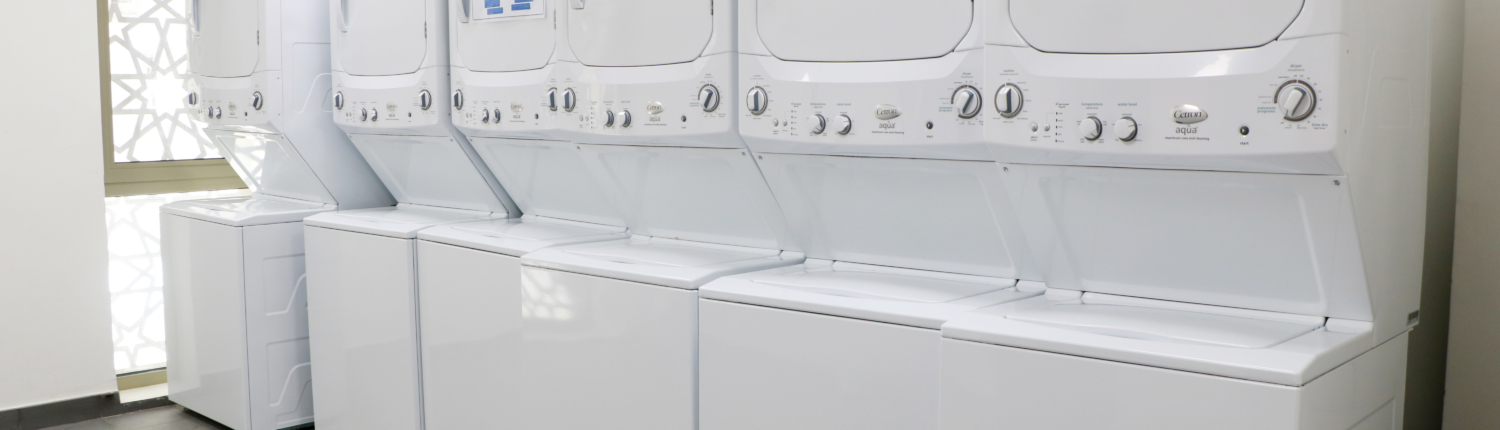 Laundry room in student housing  residences at GUtech campus, equipped with heavy duty washing and drying machines
